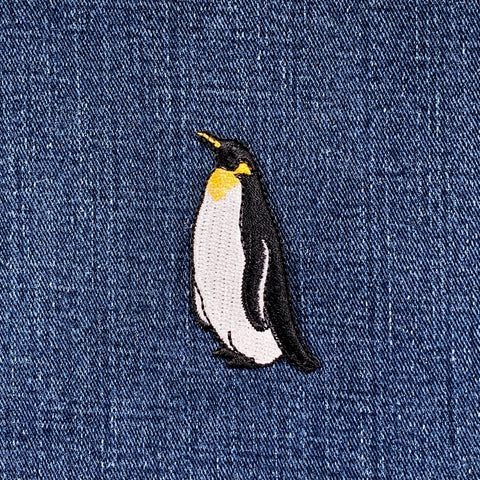 Embroidered penguin patch on denim fabric