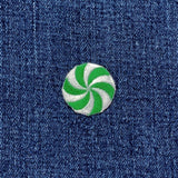 a green and white peppermint candy patch on a denim background