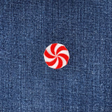 Red and white peppermint candy patch on blue denim fabric