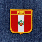 Embroidered patch of Peru's coat of arms on denim fabric