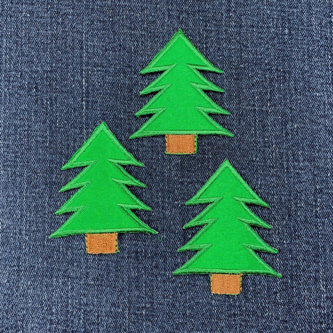 Three green tree-shaped patches on a denim background