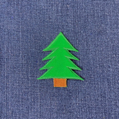 Green tree patch on blue denim fabric