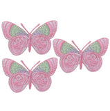 Three embroidered butterfly patches with wings primarily colored in shades of pink, pale green, and lavender, arranged in a small triangular cluster.