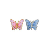 Two butterfly-shaped patches on a plain white background, one pink with gold trim and one blue with silver trim.