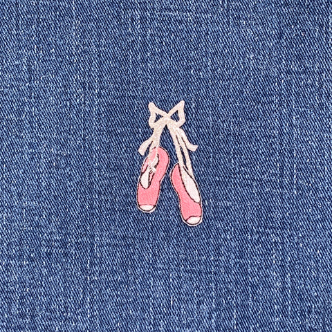 Embroidered pink ballet shoes patch on blue denim fabric