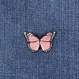 Pink butterfly patch on blue denim fabric