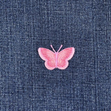Pink butterfly patch on blue denim fabric