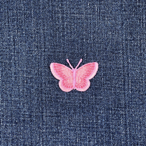 Pink butterfly patch on blue denim fabric