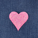 Pink heart-shaped patch on denim fabric