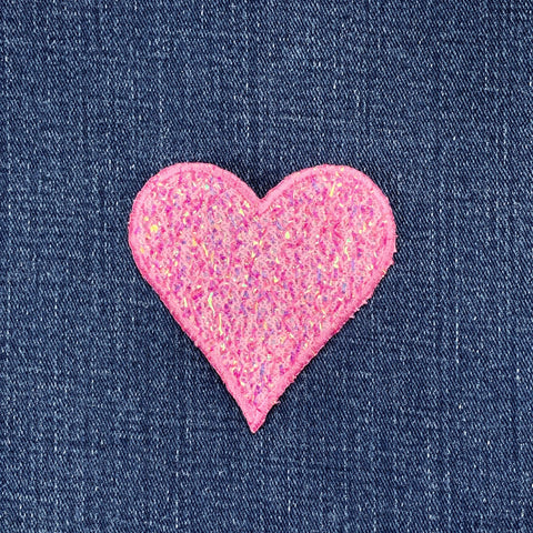 Pink heart-shaped patch on denim fabric