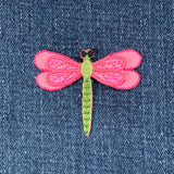 Pink and green dragonfly patch on denim fabric