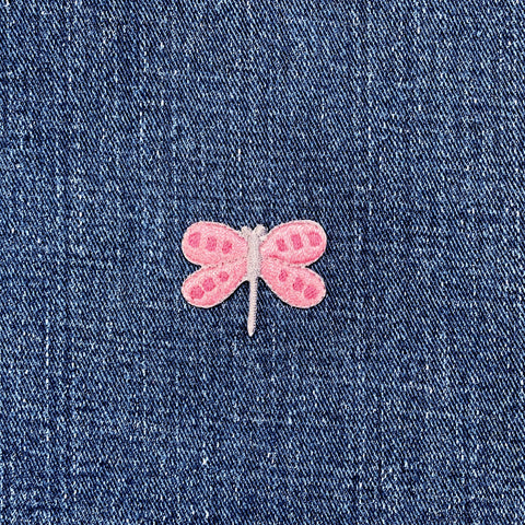 Pink dragonfly patch on blue denim fabric