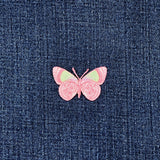 Pink butterfly patch on blue denim fabric