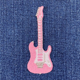 Pink electric guitar patch on blue denim fabric