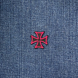 Pink and black cross patch on blue denim fabric