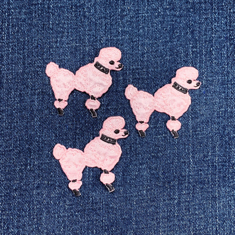 Three pink poodle-shaped patches on a denim background