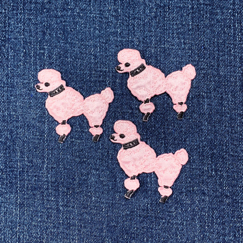 Three pink poodle dog patches on a denim background