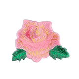 Embroidered pink rose patch with green leaves on a white background