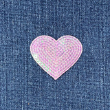 Heart-shaped pink sequin patch on denim fabric