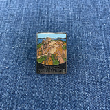 Pin with a pinnacles national park mountain design on a blue denim background