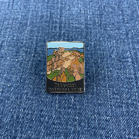 Pin with a pinnacles national park mountain design on a blue denim background