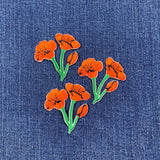 3 Orange floral poppy patches on denim fabric