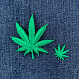 2 Green cannabis leaf patches on a denim background
