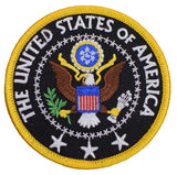 Round patch depicting the Great Seal of the United States, featuring a bald eagle, shield, olive branch, and arrows. Yellow text reads: "THE UNITED STATES OF AMERICA.