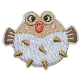 Embroidered patch of a cartoonish puffer fish with a white body and brown accents on a white background.