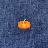 embroidered pumpkin with a green stem on a denim background