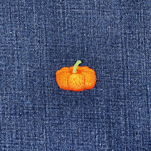 embroidered pumpkin with a green stem on a denim background