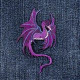 Purple embroidered dragon patch on denim fabric
