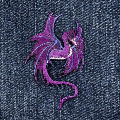 Purple embroidered dragon patch on denim fabric