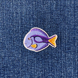 Embroidered fish patch on denim fabric