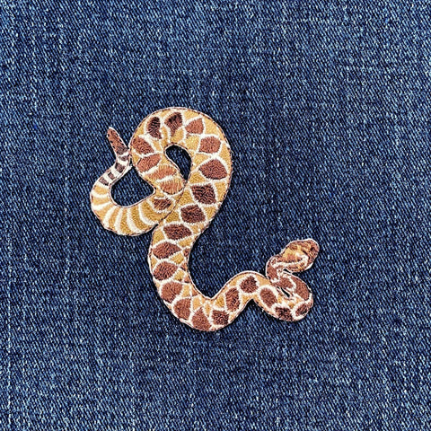Snake-shaped patch on denim fabric