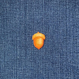 acorn applique patch on a denim background