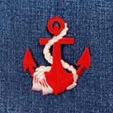 Red anchor patch with white rope on blue denim background