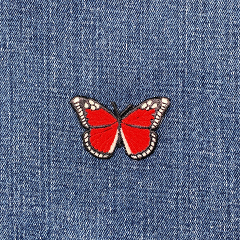 Red butterfly patch on blue denim fabric