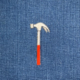 Embroidered hammer patch on blue denim fabric
