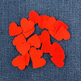 a pile of 20 red heart patches measuring 1 inch tall by 1 inch wide, displayed on a denim background
