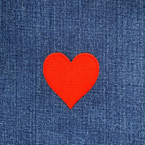 Red heart-shaped patch on blue denim fabric