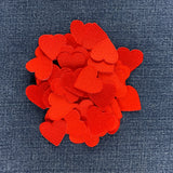 a pile of 50 mini red heart patches displayed on a blue denim background