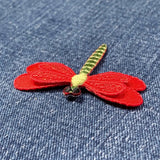 Red dragonfly patch on denim fabric