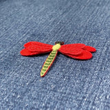 Red dragonfly patch on a denim background