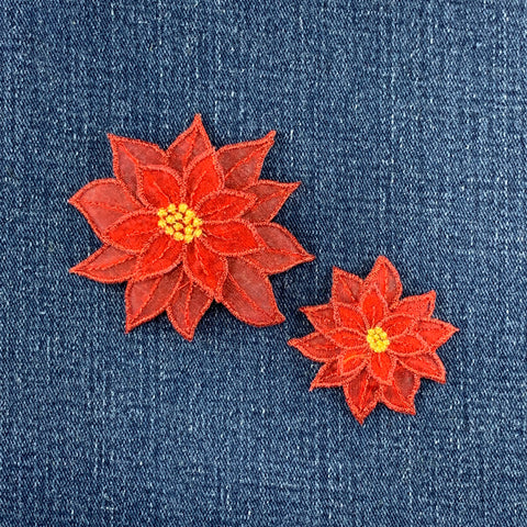 Two red floral patches with gold centers on a denim background