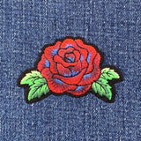 Red rose patch with green leaves on denim fabric