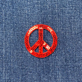 Red sequin peace symbol patch on blue denim fabric