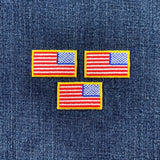 Three reverse American flag patches on a denim background