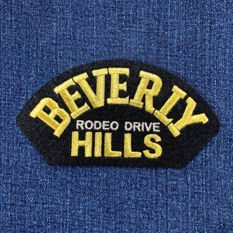 Embroidered patch with 'Beverly Hills Rodeo Drive' text on a blue fabric background