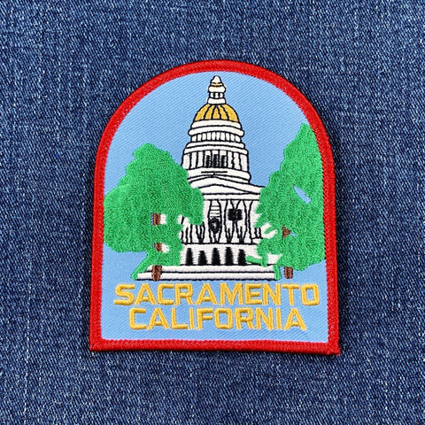A patch featuring the California State Capitol Building with green trees, blue sky, and the text 'SACRAMENTO CALIFORNIA' on a denim background.